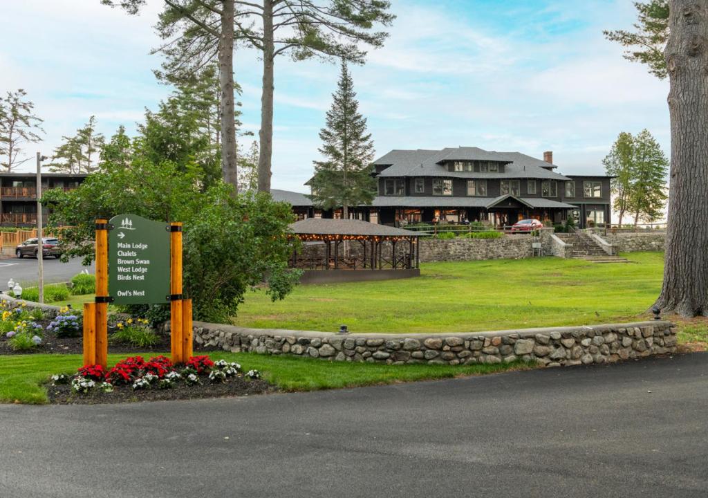 a large house with a sign in front of it at Lodge at Schroon Lake in Schroon Lake