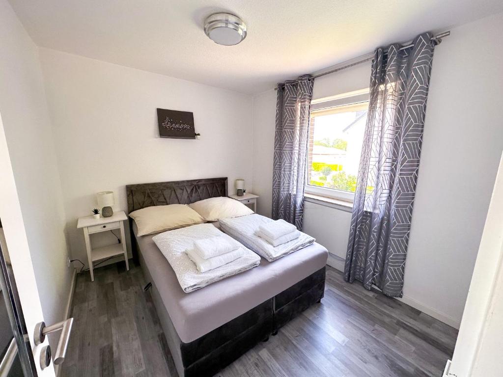 um quarto com uma cama e uma janela em Stilvolles, frisch renoviertes 2Zi Apartment mit Küche und Balkon in Kliniknähe em Bad Oeynhausen