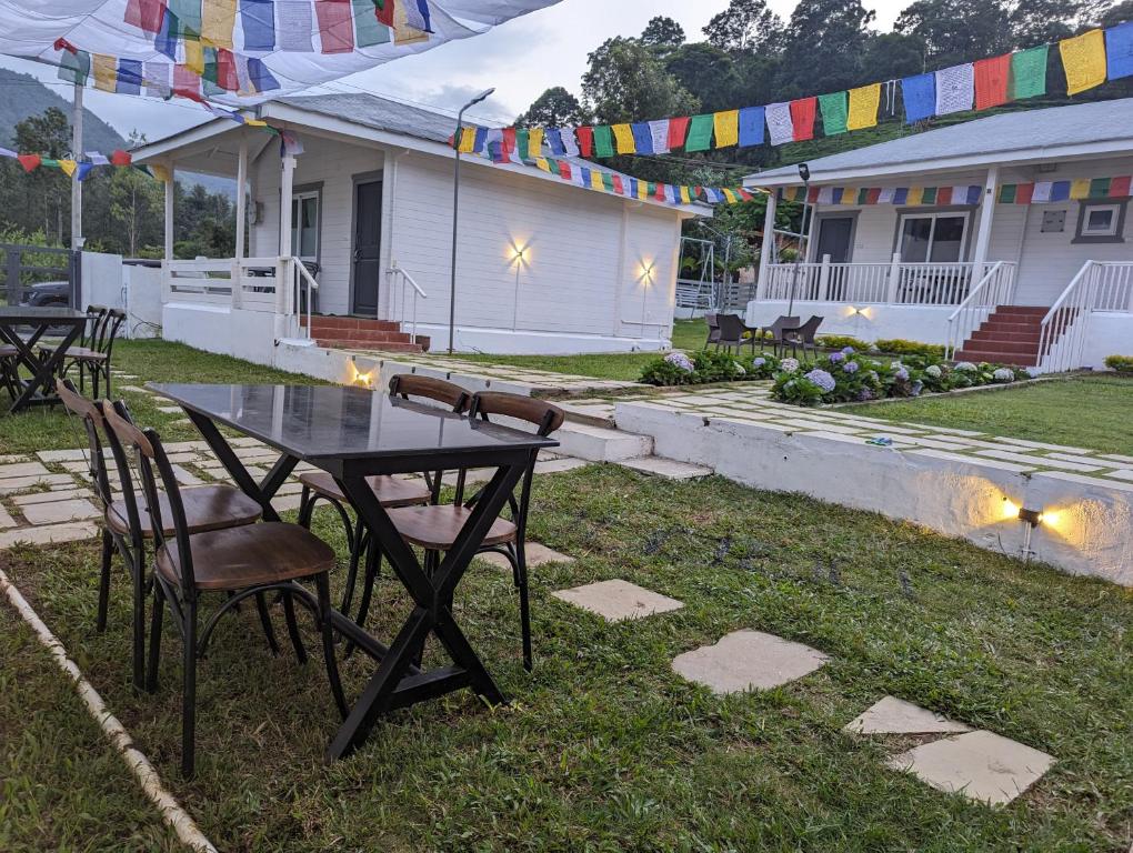 The Door to Nirvana Cottages في كونور: طاولة وكراسي في ساحة منزل