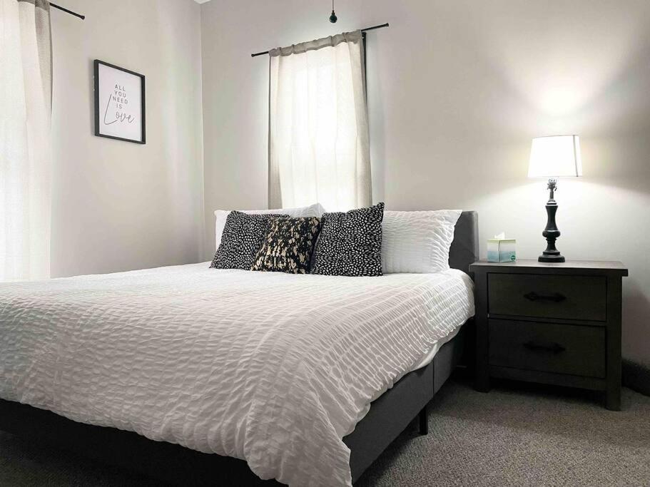 a bedroom with a bed with a nightstand and a window at Leaning House of Haynie in Evansville