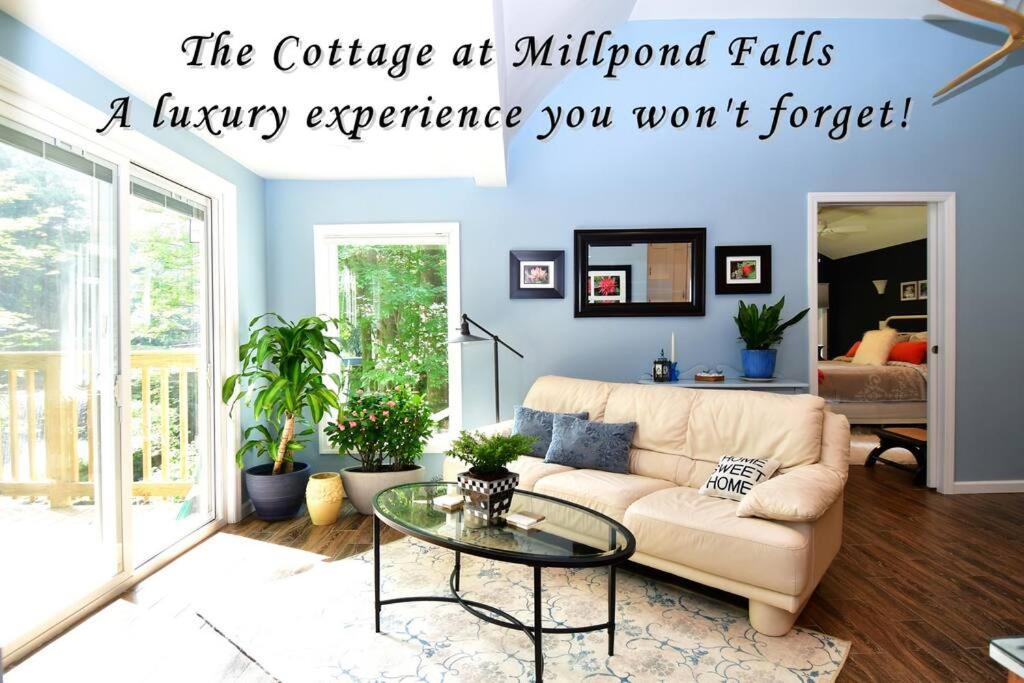 Una sala de estar con un sofá y una mesa de cristal. en Luxury Cottage at Millpond Falls, en Warwick
