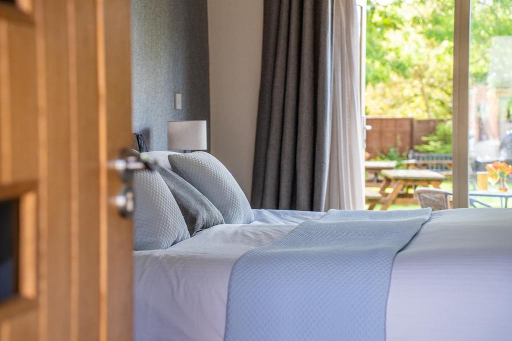 a bedroom with a bed and a view of a patio at The Honingham Buck in Norwich
