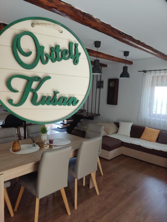 a living room with a table and a sign at Kuća za odmor Obitelj Kušan 