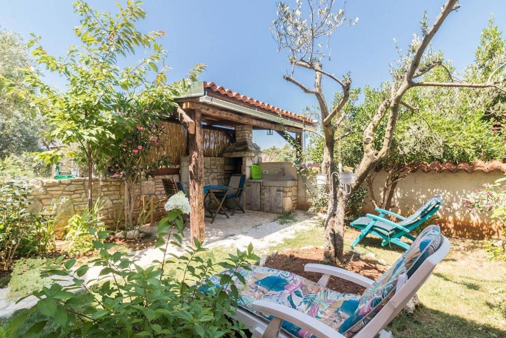 a garden with two chairs and a gazebo at Villa Marizella in Premantura