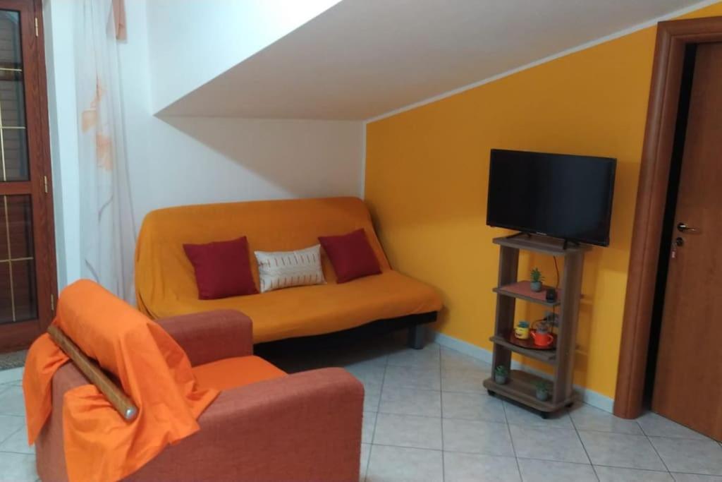sala de estar con sofá y TV en Splendido Attico, en Roseto Capo Spulico