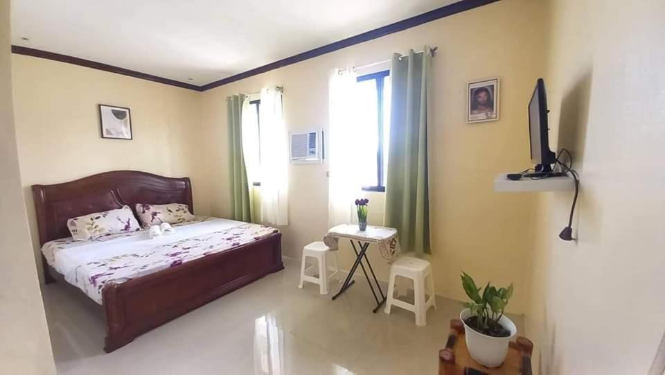 sypialnia z łóżkiem, stołem i telewizorem w obiekcie La Residencia Tacloban w mieście Tacloban
