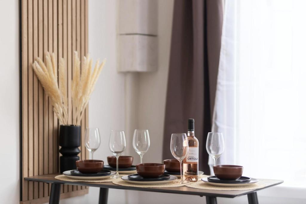 - une table avec des verres à vin et des bouteilles de vin dans l&#39;établissement Bright 30 m near the Place de la Comédie, à Montpellier