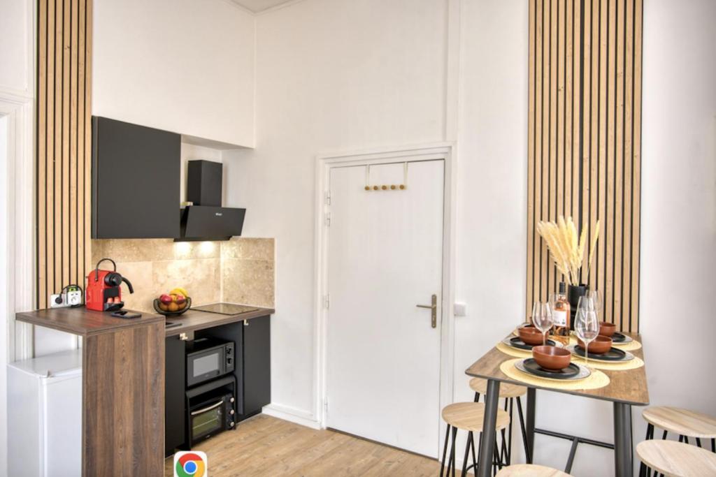 une cuisine avec un comptoir et une table avec des chaises dans l&#39;établissement Bright 30 m near the Place de la Comédie, à Montpellier