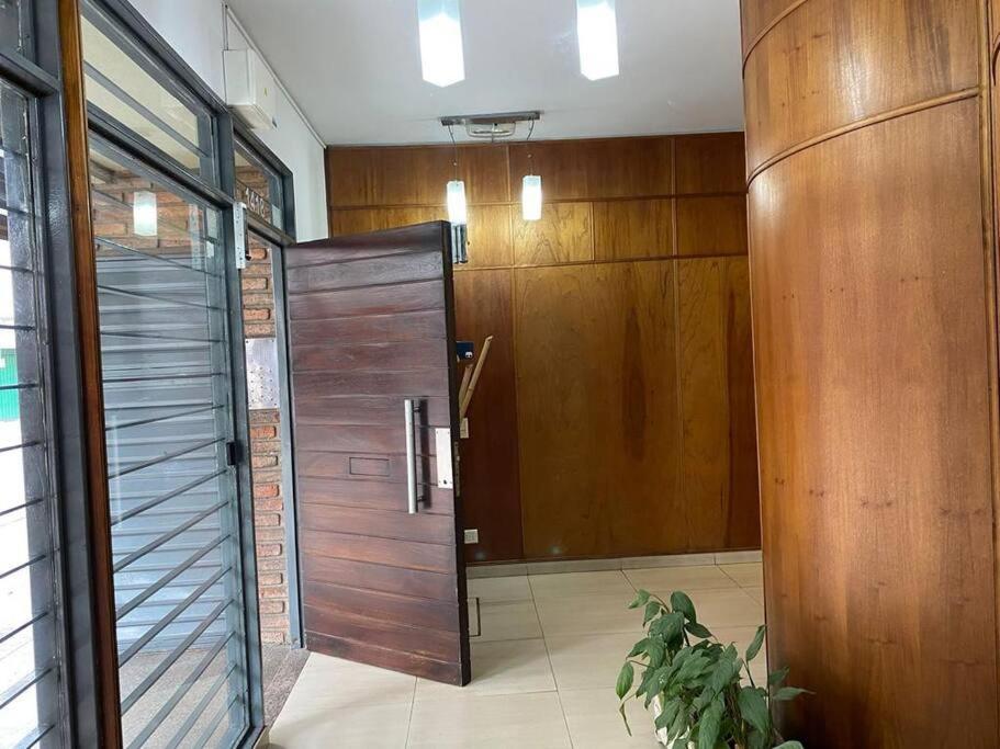 a bathroom with a wooden door in a room at Departamento Necochea in Rosario