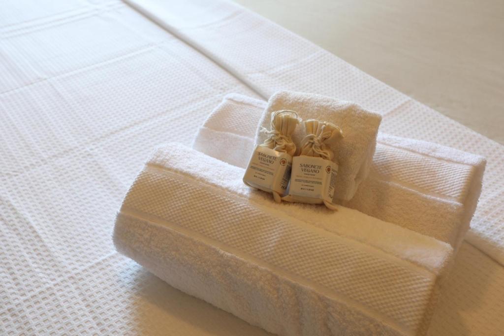 a white bed with two little candles on it at Studio Savana in São Paulo