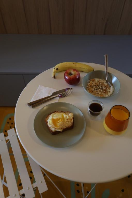 a table with plates of food and an apple and a banana at Studio Savana in São Paulo