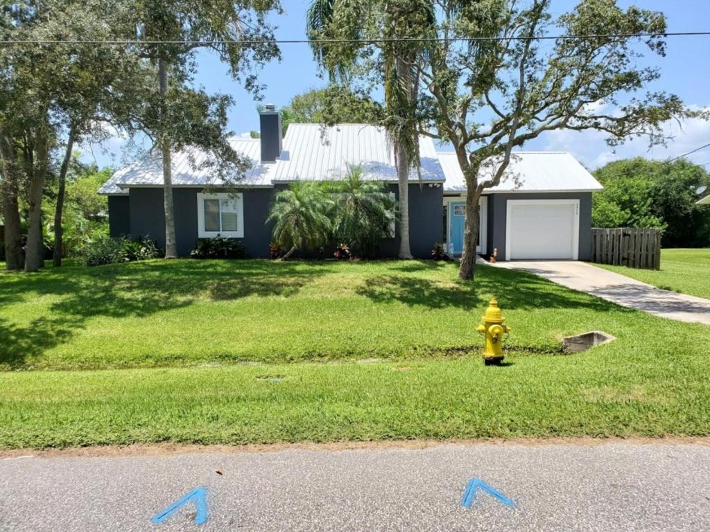 a yellow fire hydrant in front of a house at Floridays in Butler Beach