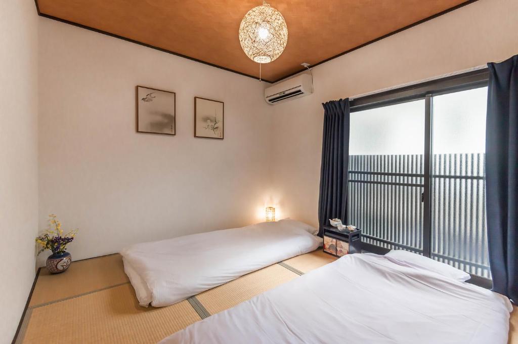 Postel nebo postele na pokoji v ubytování 桜の宿千本 two rooms two toilets