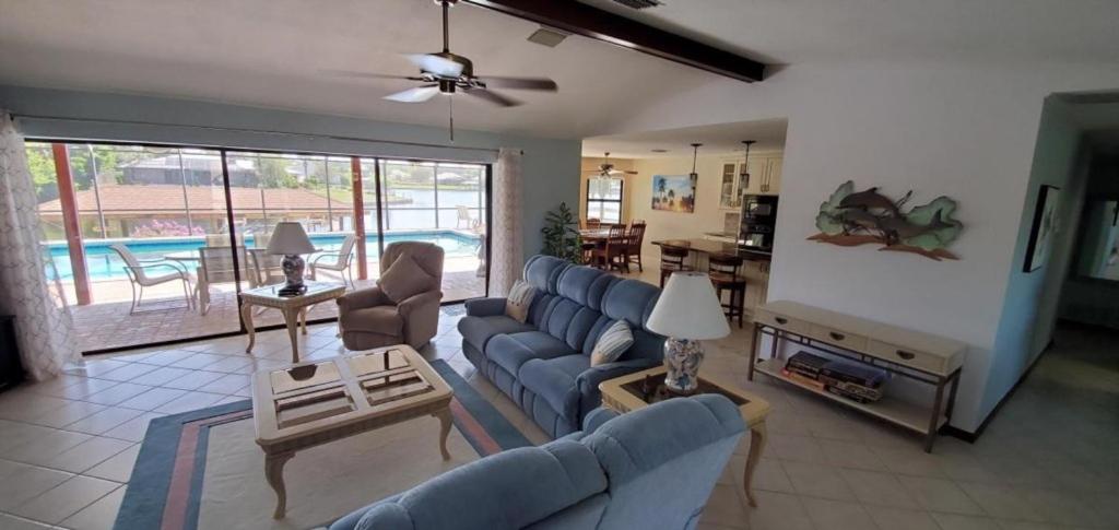 a living room with blue couches and a living room with a pool at Getaway Canal in Palm Coast