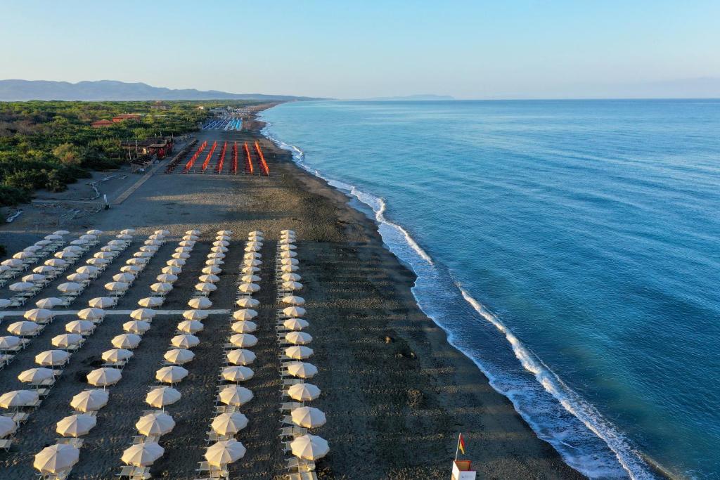 eine Luftansicht auf einen Strand mit Sonnenschirmen in der Unterkunft Park Hotel Marinetta - Beach & Spa in Marina di Bibbona