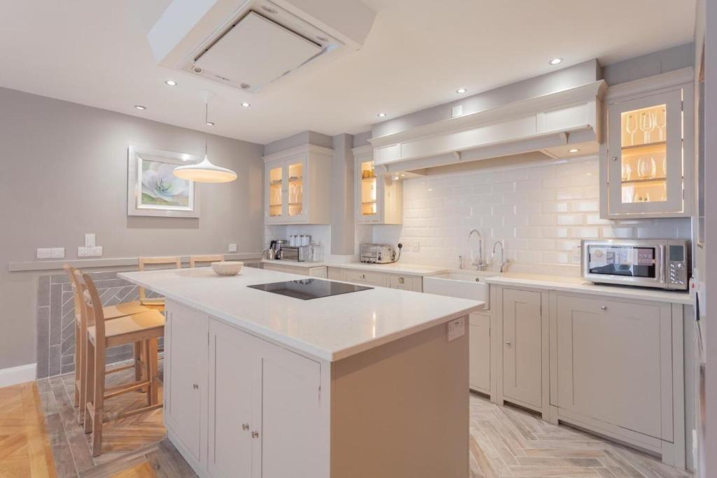 a kitchen with white cabinets and a white counter top at Central Belfast Apartments Alfred Street in Belfast
