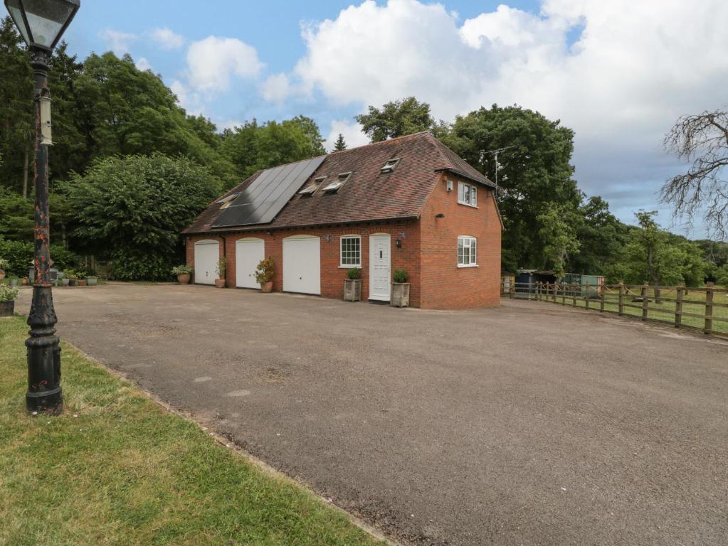 um edifício de tijolos vermelhos com um telhado preto em Whitlow Lodge Annex em Gloucester