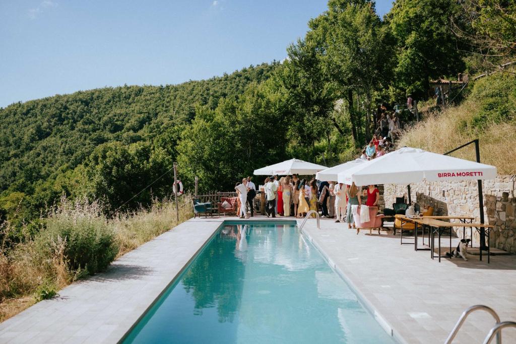 um grupo de pessoas em pé em torno de uma piscina em novanta nature retreat em Bibbiena