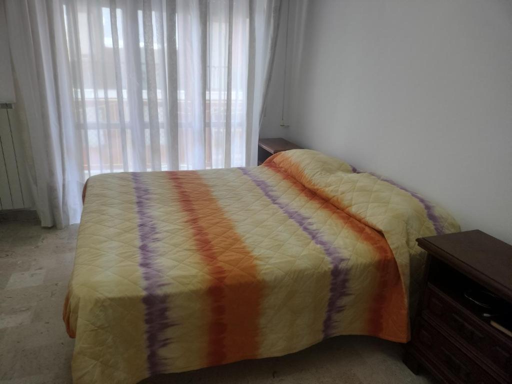 een bed met een kleurrijk dekbed in een slaapkamer bij Alloggio Maria in San Bartolomeo al Mare