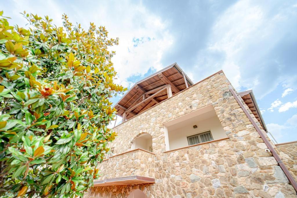 a house with a stone wall and a tree at Luxury Room in Montecatini Terme