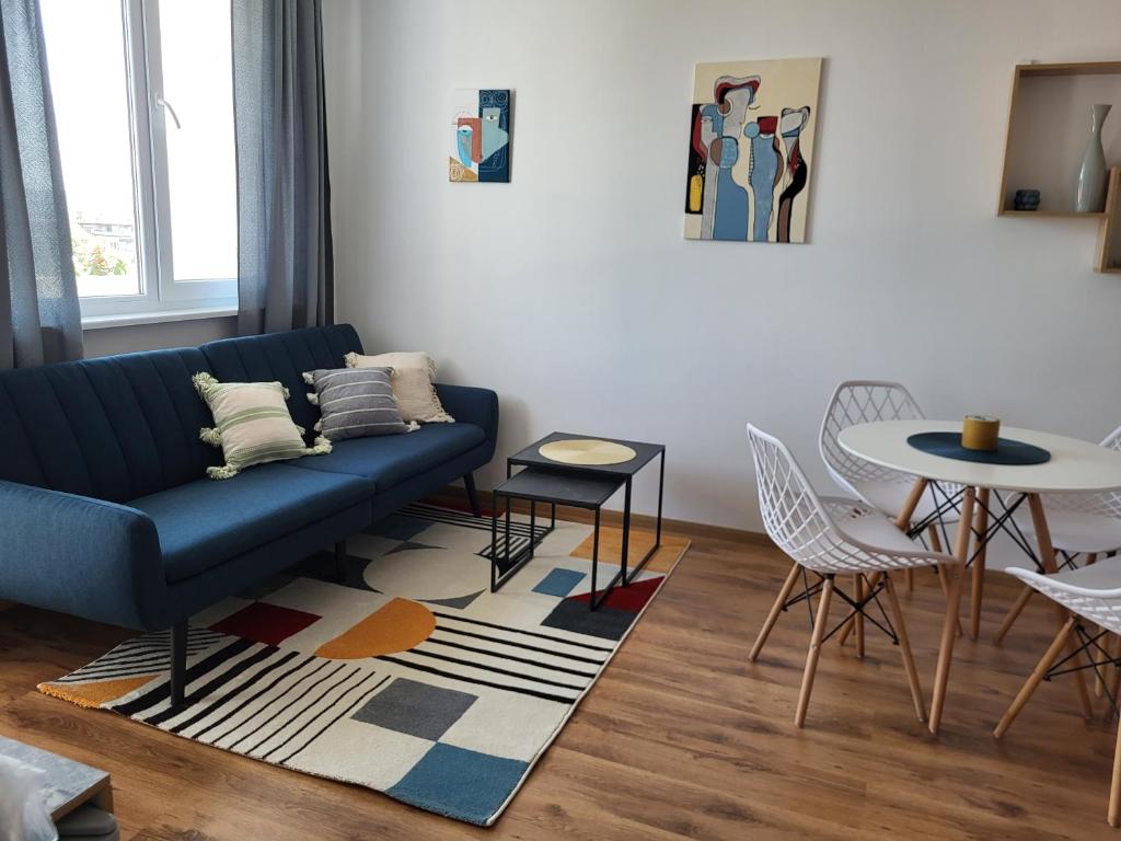 a living room with a blue couch and a table at SiSi Art in Varna City