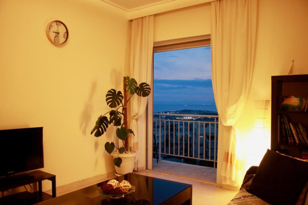 sala de estar con ventana grande con vistas en Penthouse with Sea View, en Atenas