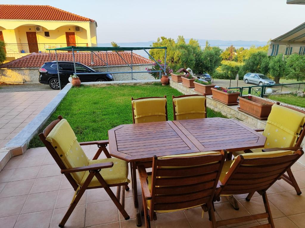 a wooden table and chairs on a patio at ΛΕΛΑ in Kriopigi