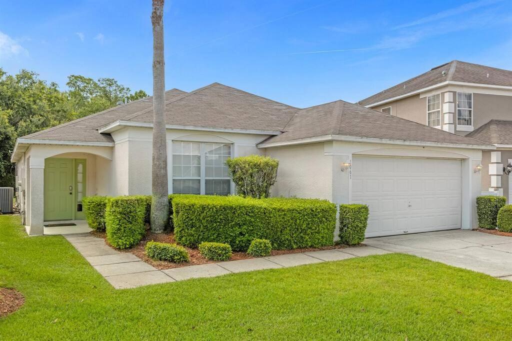 a house with a green door in a yard at 1061 Lake Berkley 4 Bed with Pool&Spa in Kissimmee