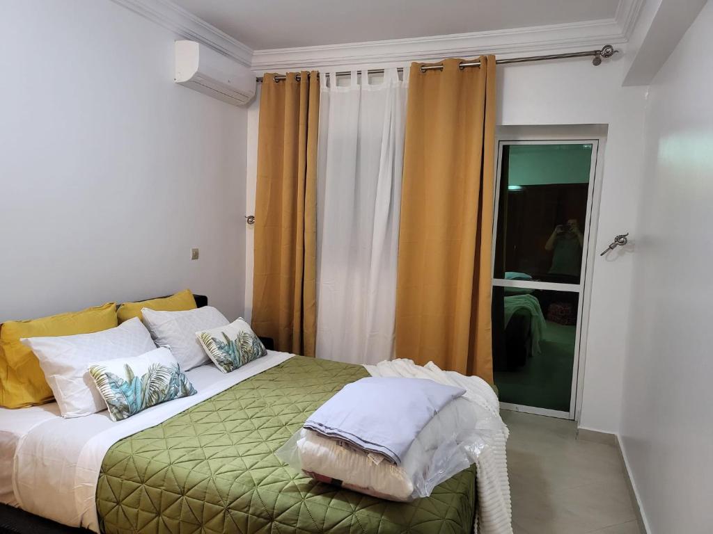 a bedroom with a large bed with yellow curtains at Zemmouri in Tangier