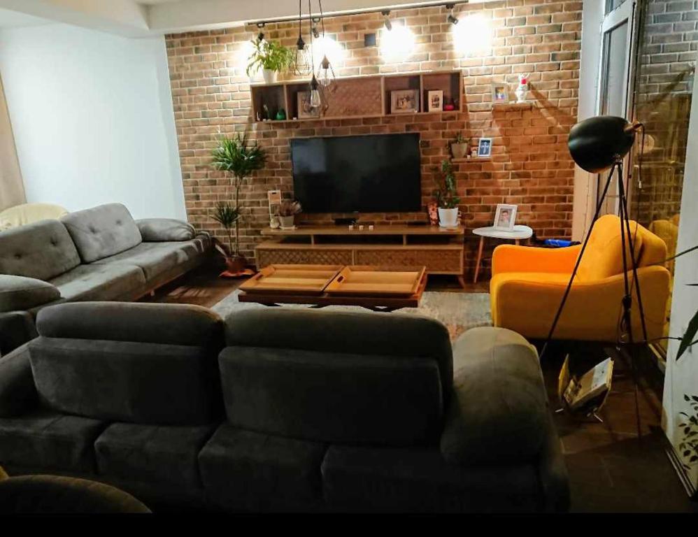 sala de estar con sofá y TV en COSMO Apartman Prilep en Prilep
