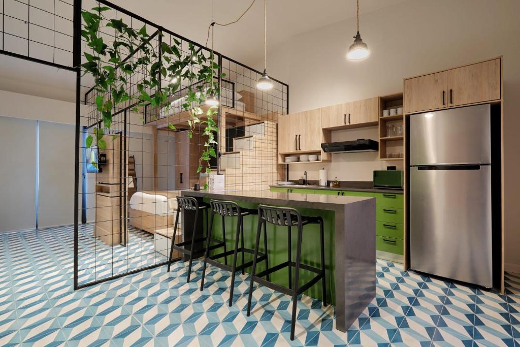a kitchen with green cabinets and a stainless steel refrigerator at Comfy Loft in Santa Ana in Santa Pera