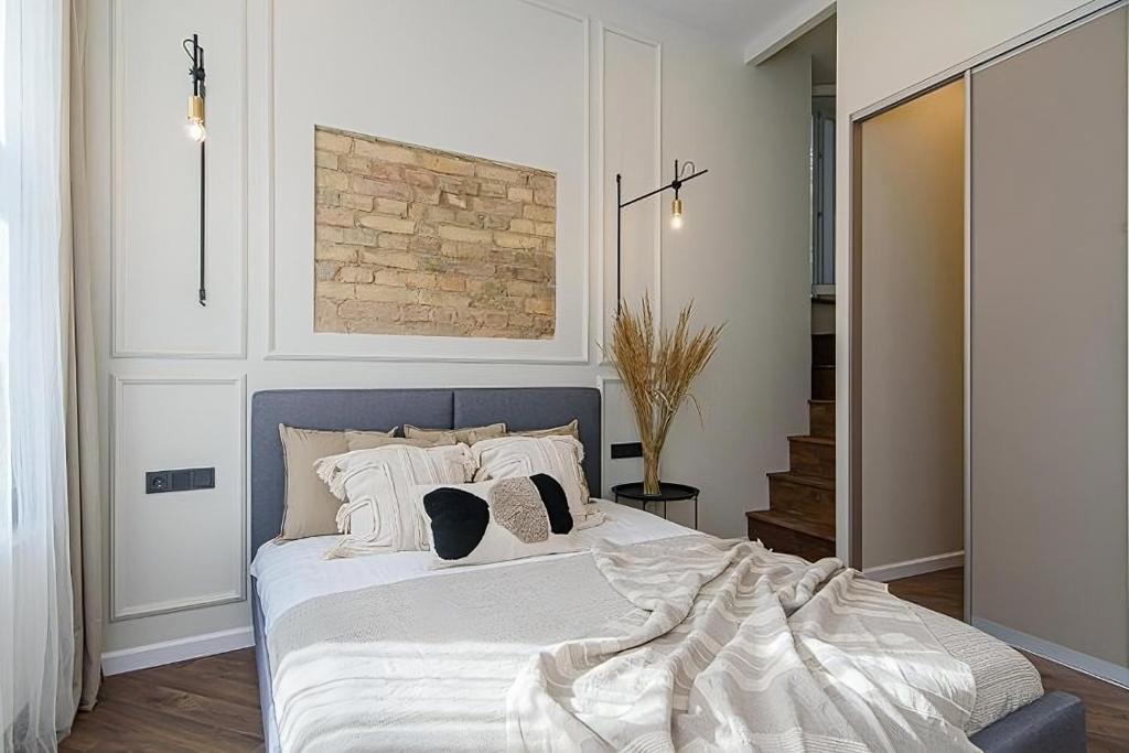 a bedroom with a bed with white sheets and pillows at FREE PARKING Old Town Central Station Apart with Balcony in Vilnius