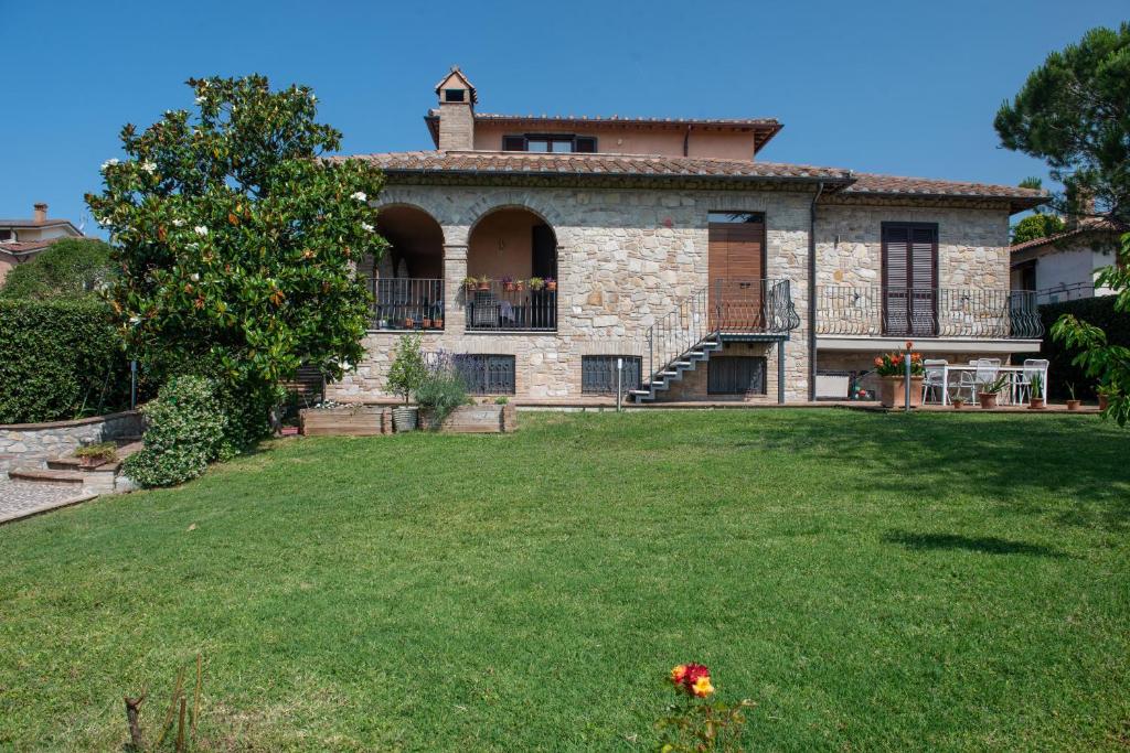 a large stone house with a yard in front of it at Dolce Alba in Montecastrilli