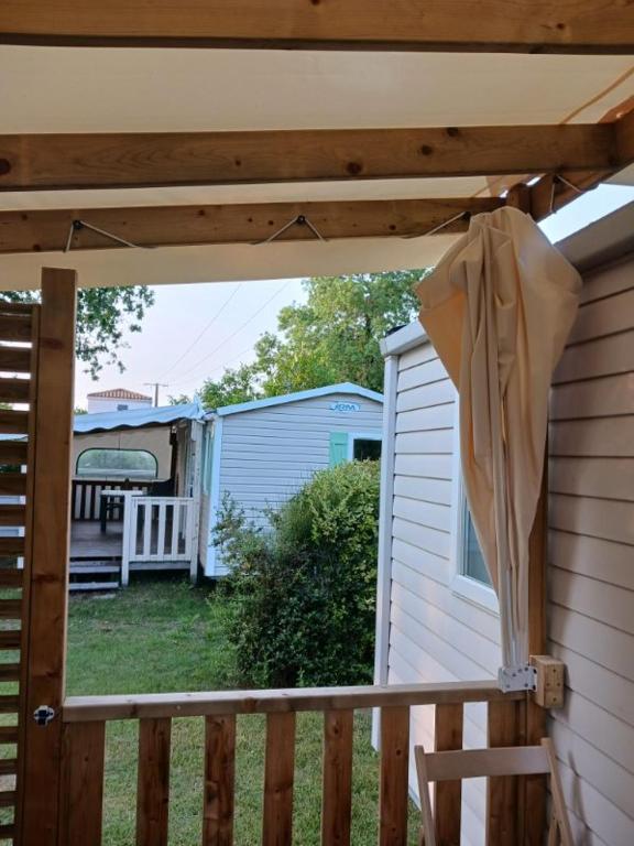 awning over a porch of a house with a yard at Mobilhome 6 pers avec Clim in Saint-Georges-de-Didonne