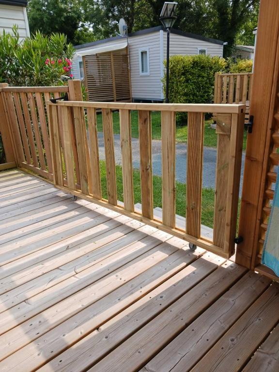 a wooden deck with a gate on a house at Mobilhome 6 pers avec Clim in Saint-Georges-de-Didonne