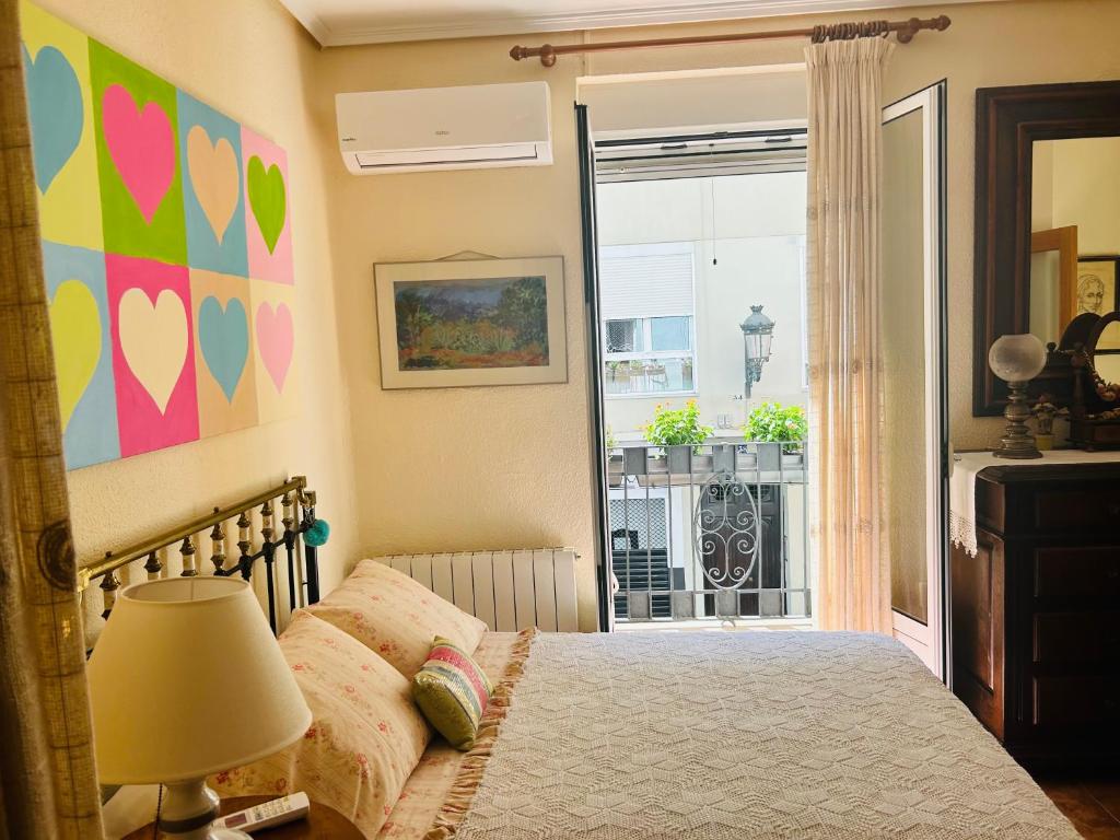 Schlafzimmer mit einem Bett und Blick auf einen Balkon in der Unterkunft HABITACIÓN DOBLE o TRIPLE CORAZON DE RUZAFA in Valencia