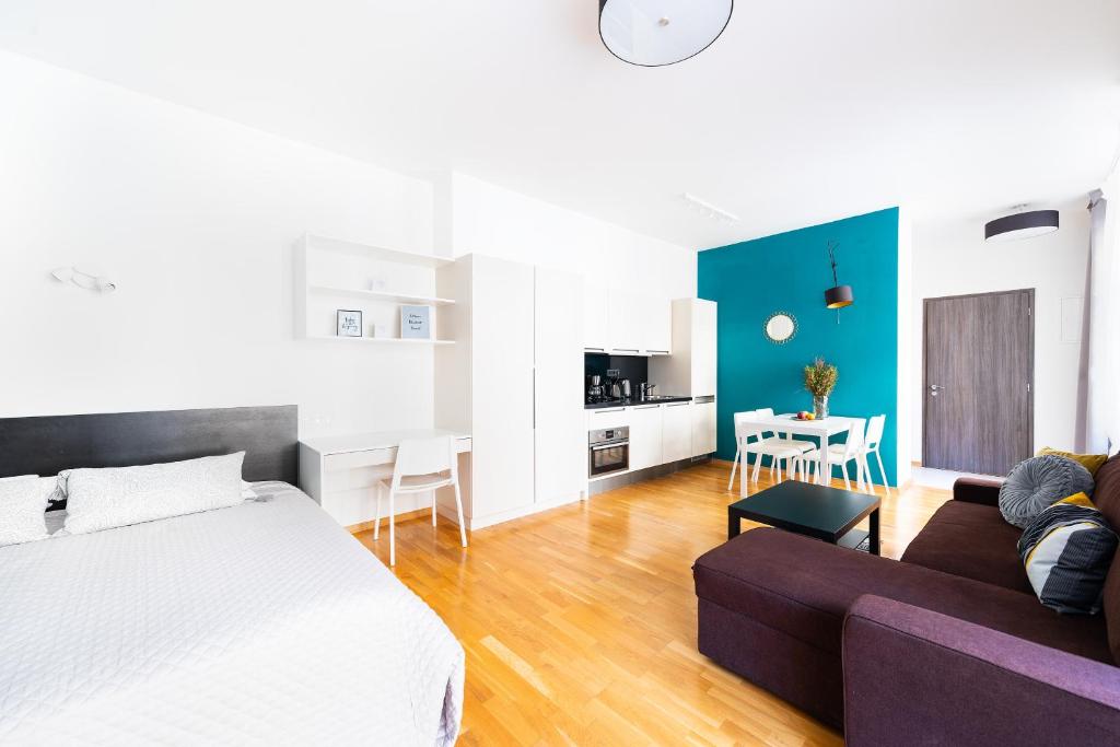 a bedroom with a bed and a couch and a table at Bohéme Apartments Charle's Square in Prague
