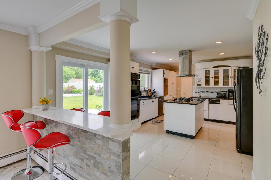 cocina grande con electrodomésticos blancos y sillas rojas en Medford Home with Pool, Near Golf Courses!, en Medford