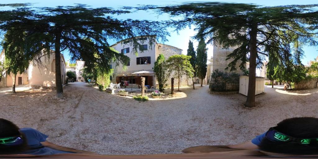 un patio con un edificio y árboles en Srećko en Bale