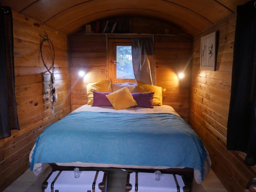 a bedroom with a bed in a wooden cabin at Maison Dougnac La Chamane in Fleurance