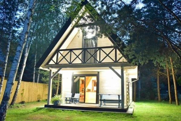 ein kleines Haus mit einer Veranda und Bänken im Hof in der Unterkunft Biały Domek in Żary