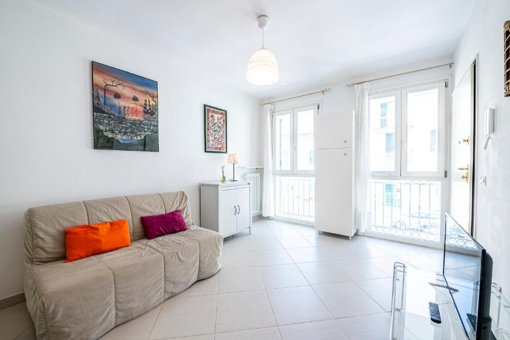 ein Wohnzimmer mit einem Sofa und einigen Fenstern in der Unterkunft [Fronte Mare]-Sweet Home-[Free Parking] in Marina di Pisa