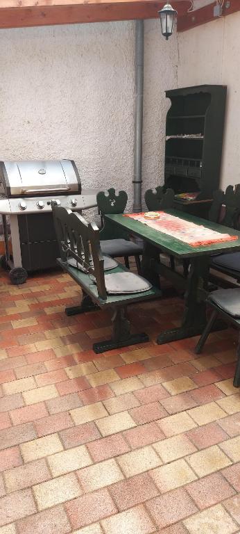 a table and chairs in a room with a stove at Bora Vendégház in Eger