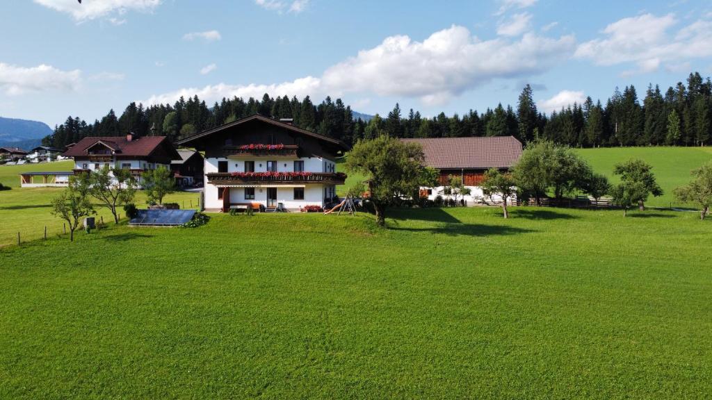 uma casa num campo com um grande campo verde em Vorderwimmhof em Abtenau
