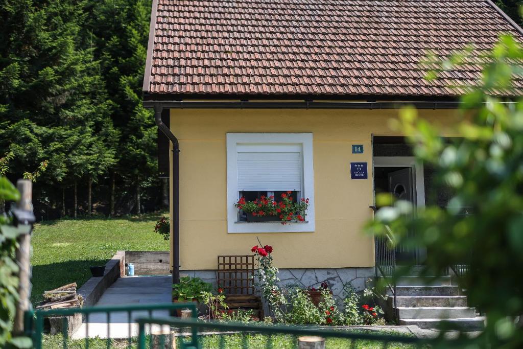ein kleines Haus mit einem Fenster mit einem Blumenkasten in der Unterkunft Holiday House Provance in Brod na Kupi