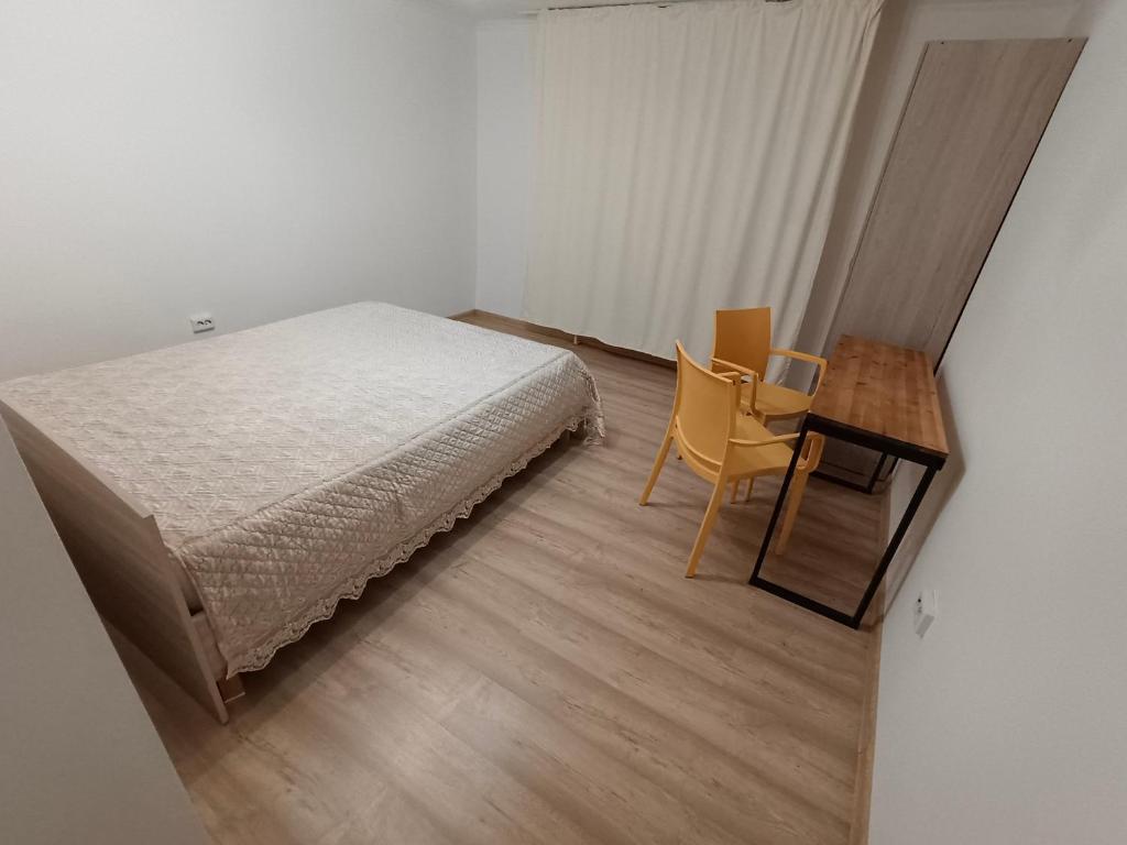 1 dormitorio con 1 cama, 1 mesa y 1 silla en Ohana Boutique, en Astana