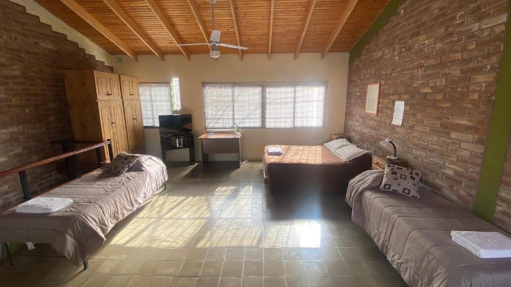 Habitación con 2 camas y pared de ladrillo en Monoambiente Luminoso y Tranquilo en Mendoza