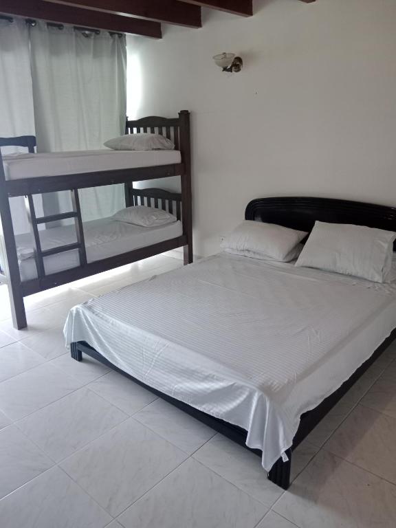 a bedroom with a large bed and a bunk bed at Habitaciones en Familia in San Andrés