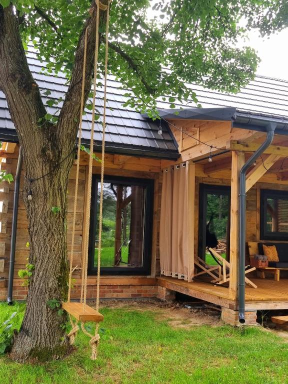 Ein Haus wird zwischen einem Baum und einer Schaukel gebaut. in der Unterkunft Sosnowy Plan in Józefów