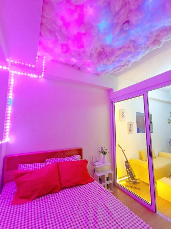 a pink bedroom with a bed with a pink ceiling at The Celandine Residences By HJM in Manila